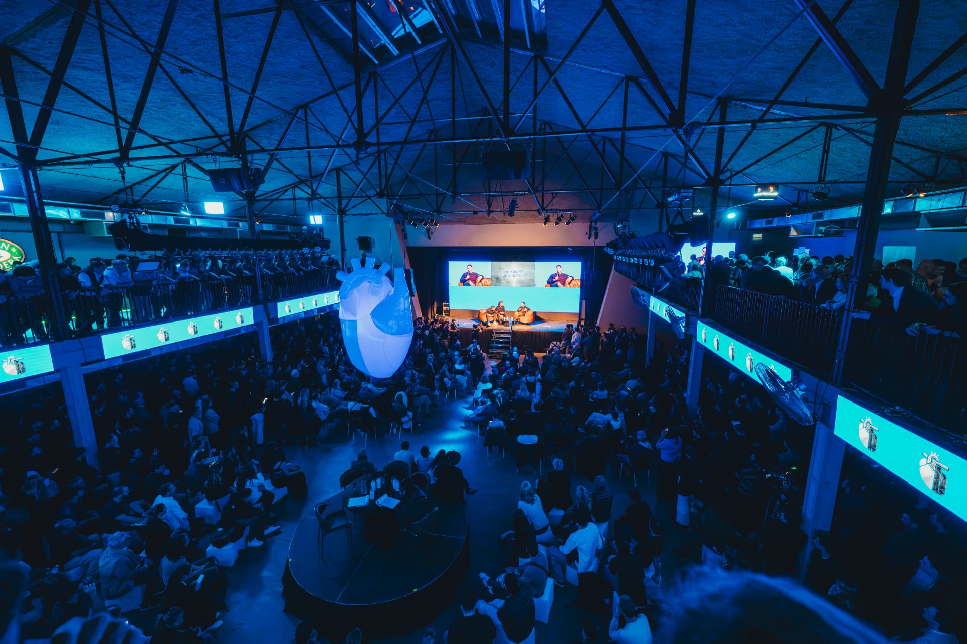 El salón completo iluminado de azul durante una charla